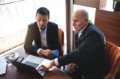 two senior businessmen with laptop meeting at cafe