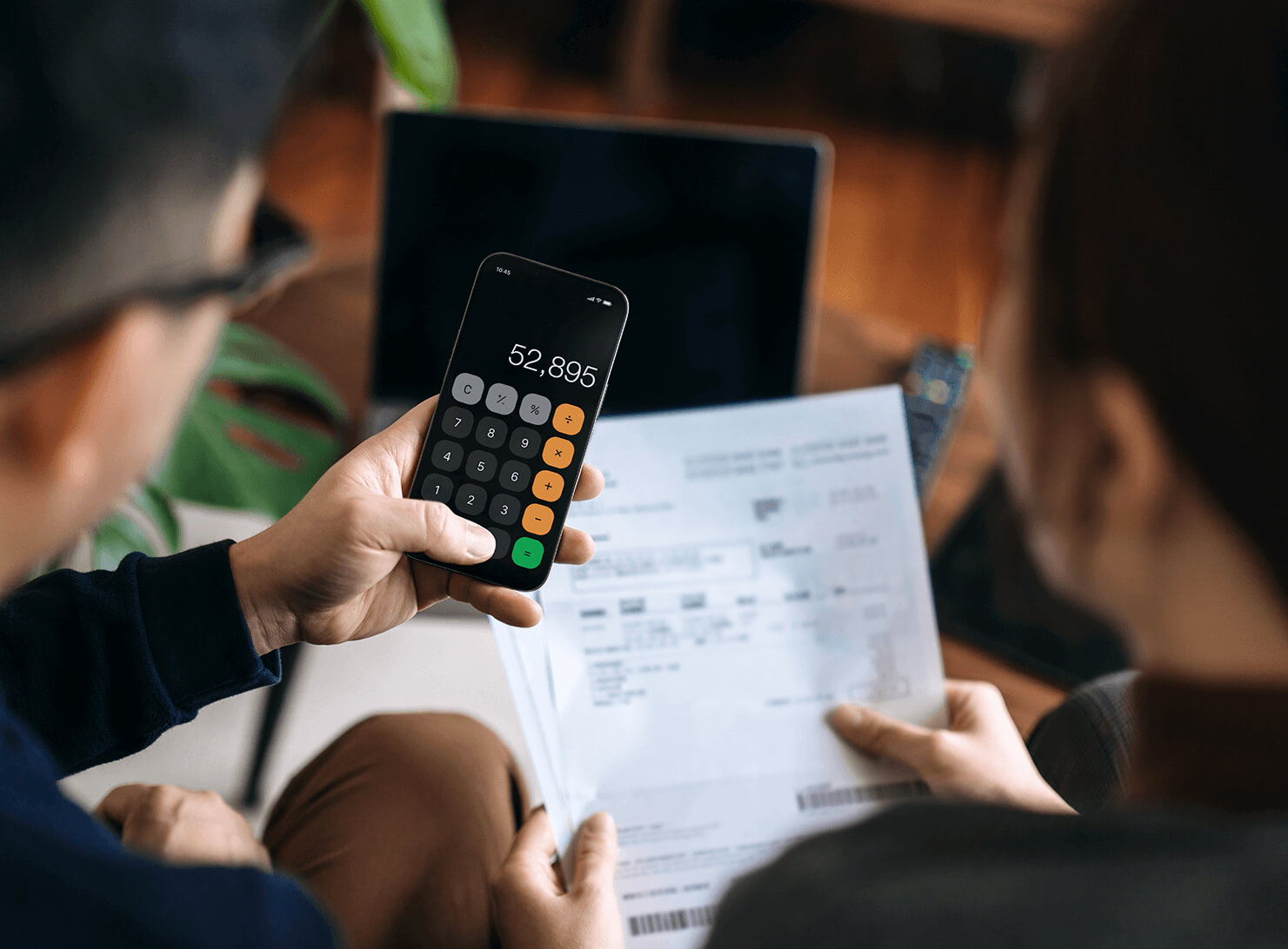 two people looking at calculator 