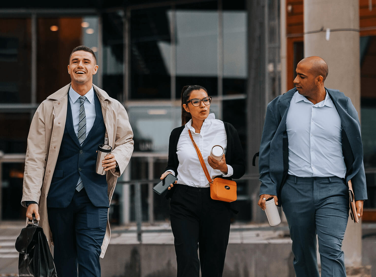 three people walking outside office building