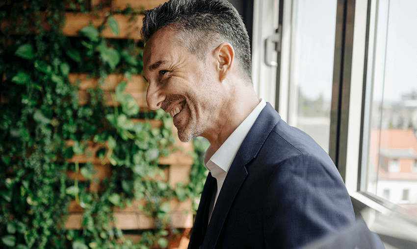 man smiling by window in office